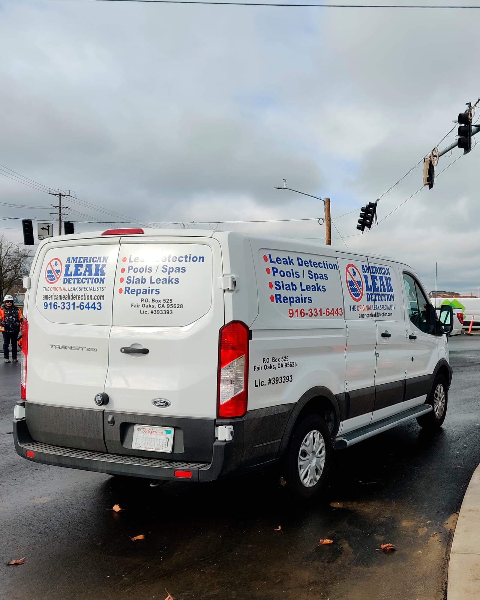 American Leak Detection of Sacramento service van parked on a wet Sacramento street.