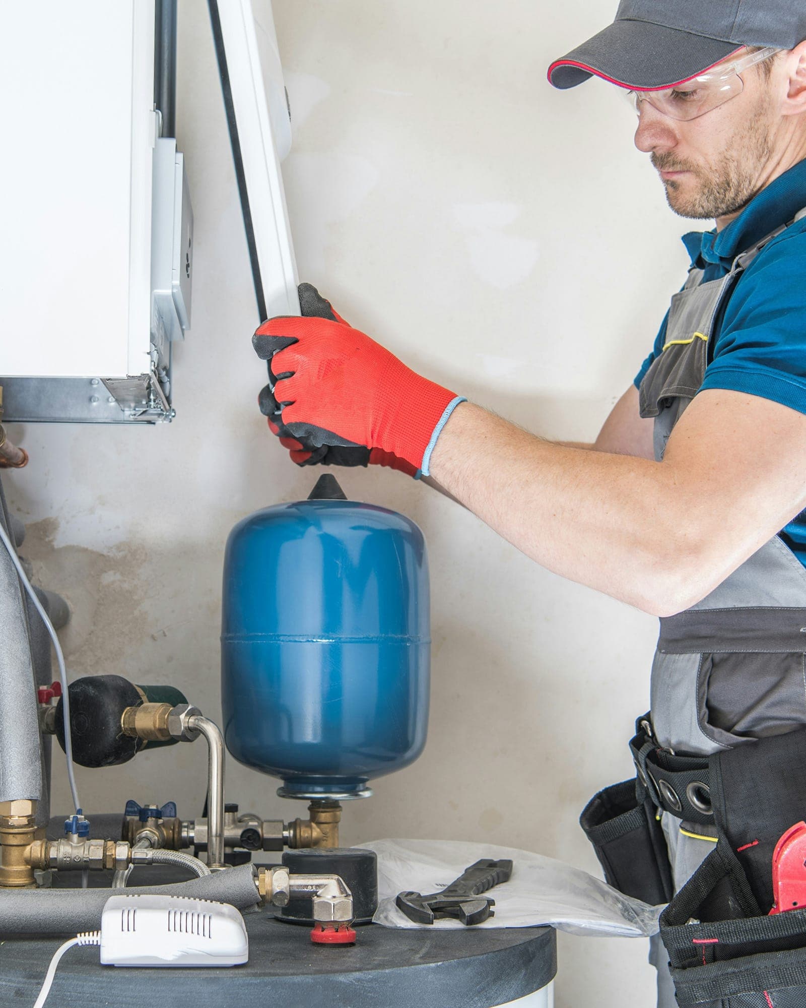 Technician checking pressure-tank equipment inside a Nevada County utility room.