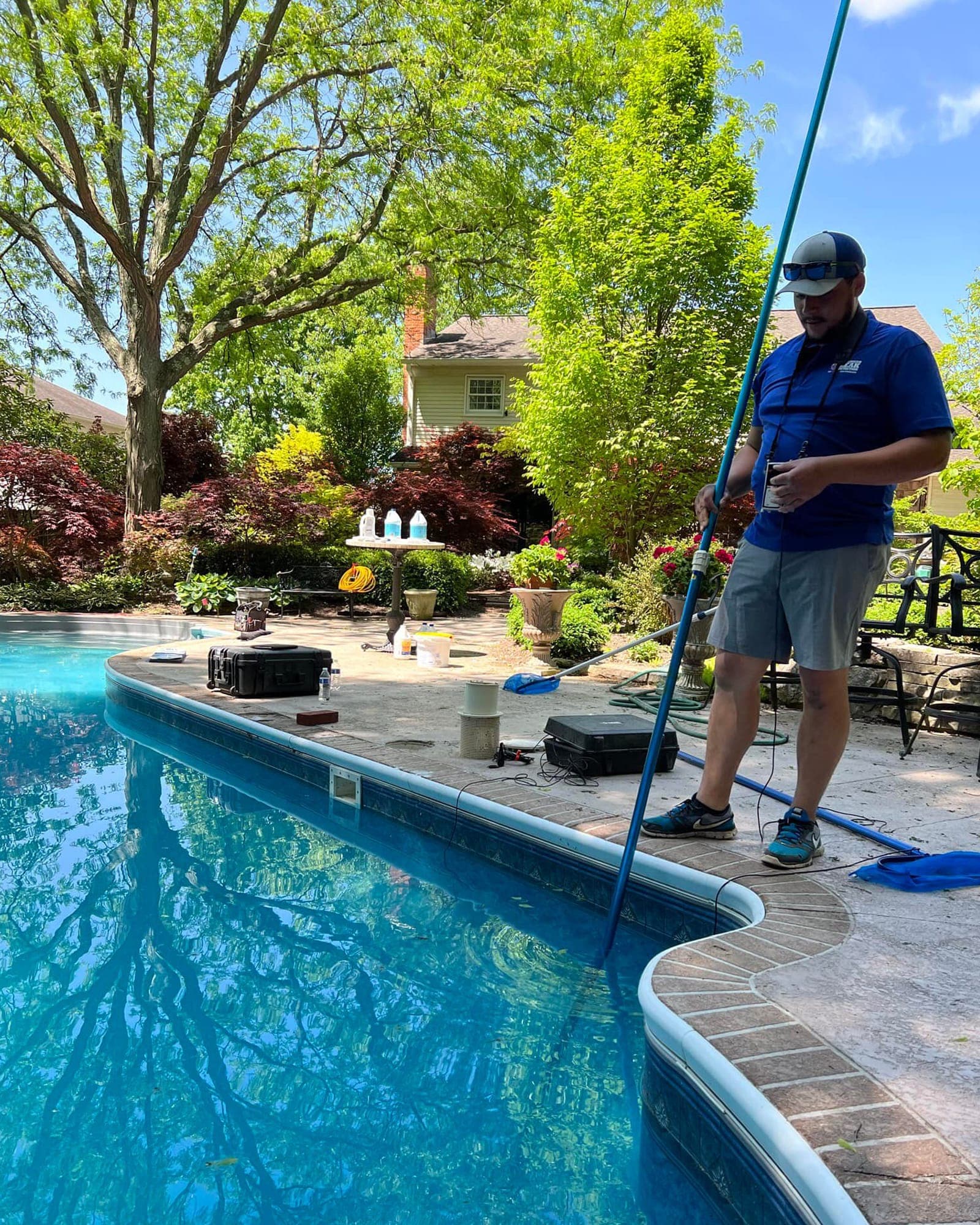Technician checking pool equipment beside a Yuba County backyard pool.