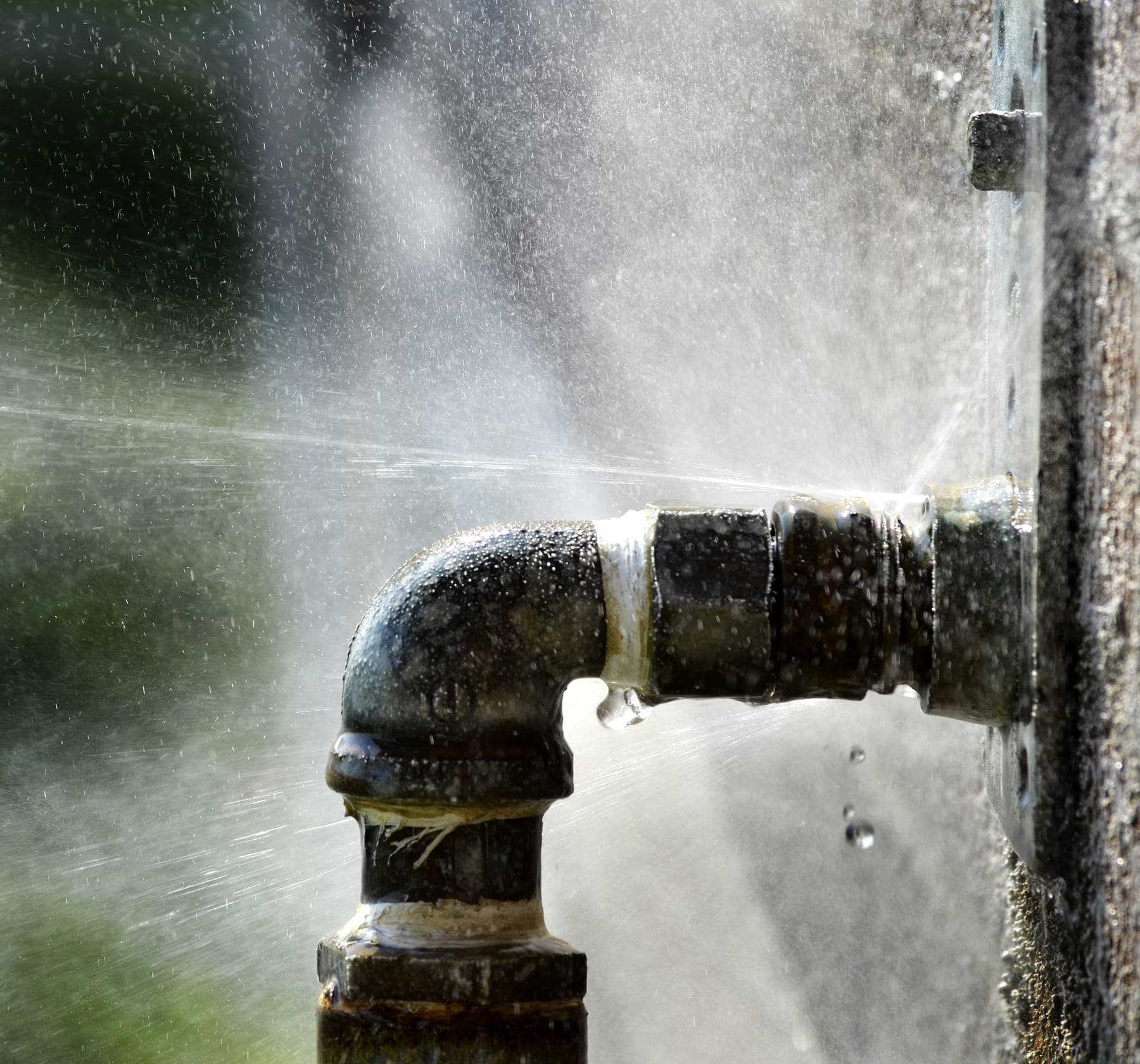 Pressurized pipe spraying water during an active leak detection call.