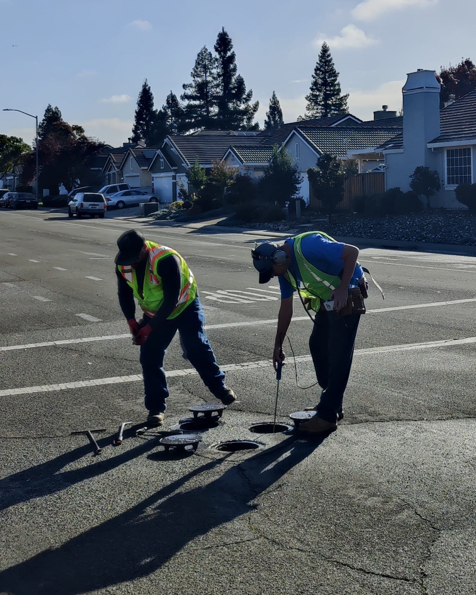 Municipal leak survey crew working in a residential street.