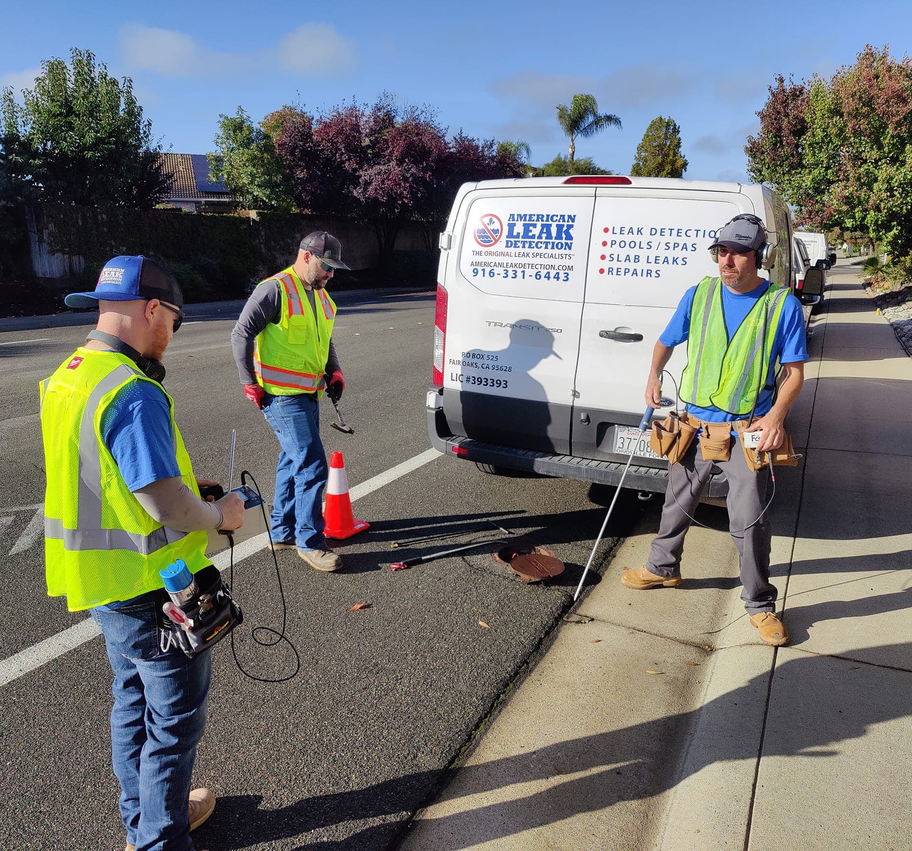 Municipal leak survey crew standing near an American Leak Detection service van.