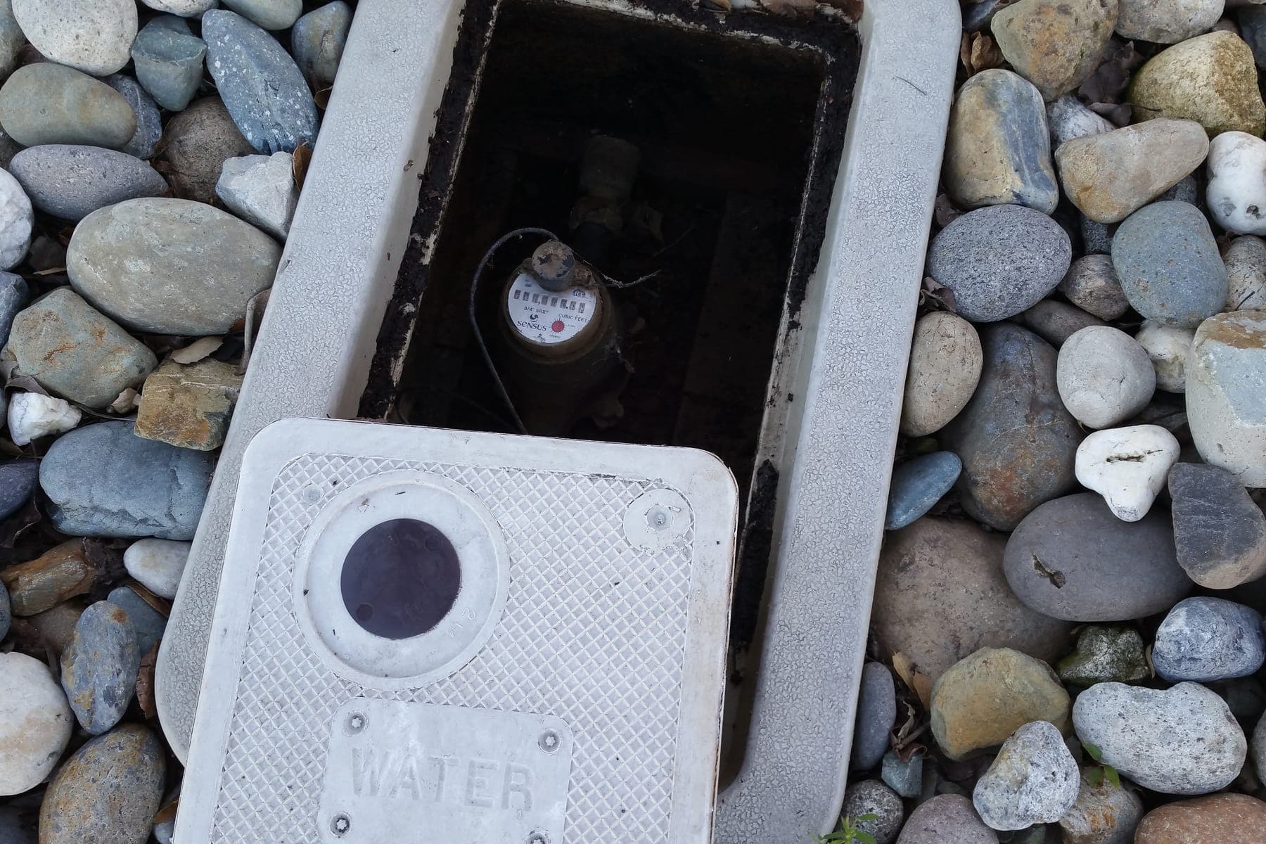 Open water meter box during a municipal leak survey.