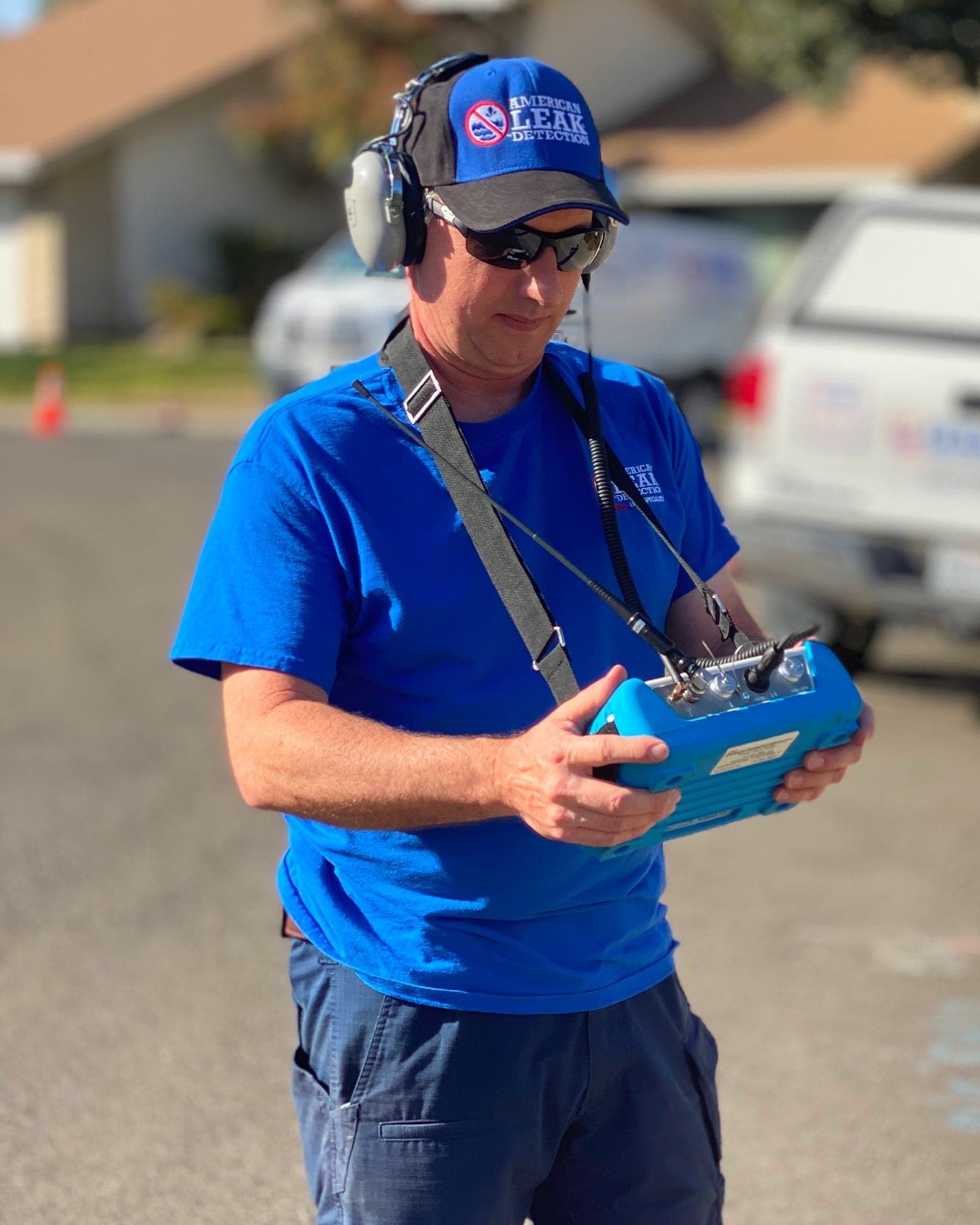 American Leak Detection technician using acoustic listening equipment at a commercial property.