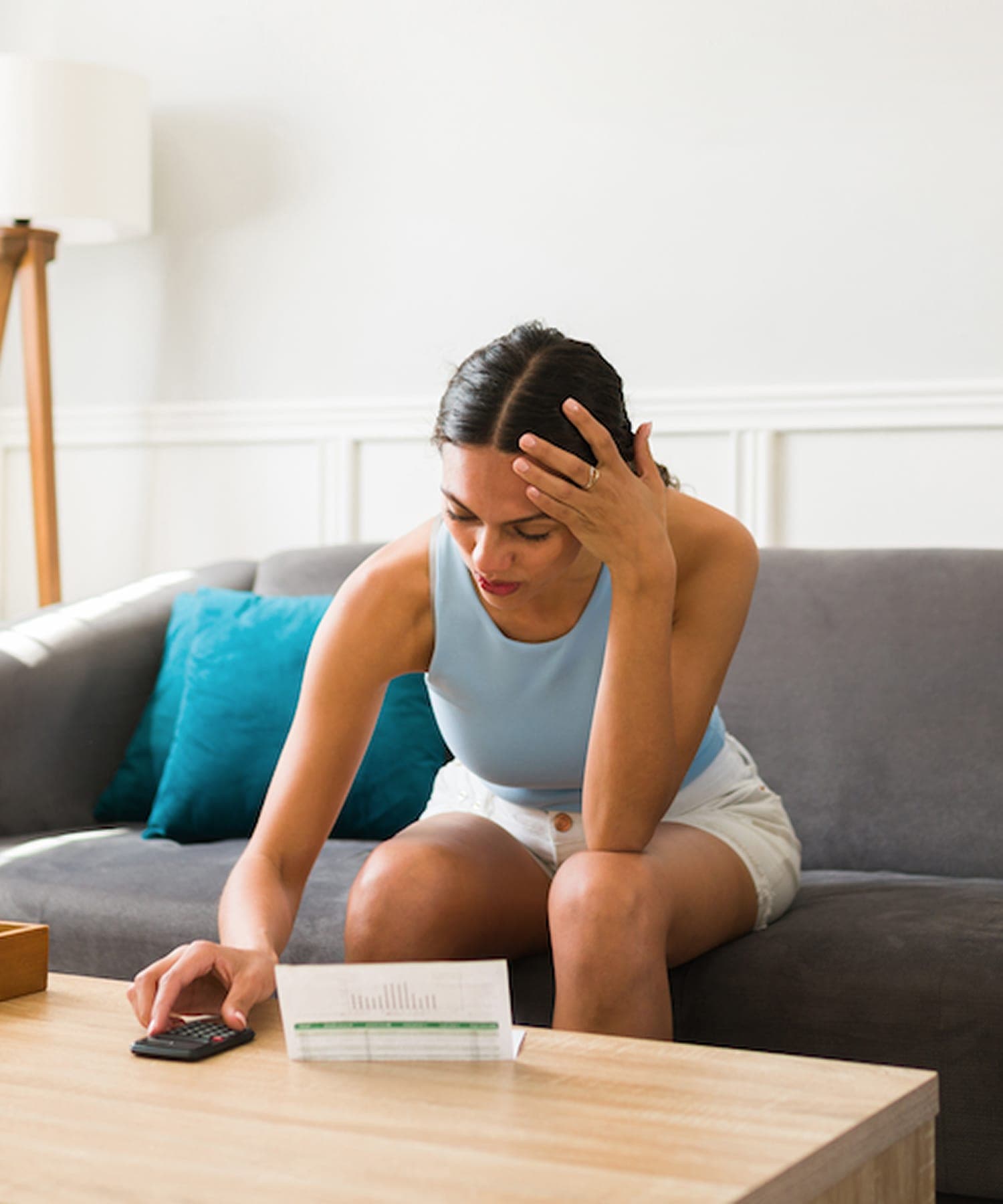Homeowner reviewing a high water bill at a living room coffee table.