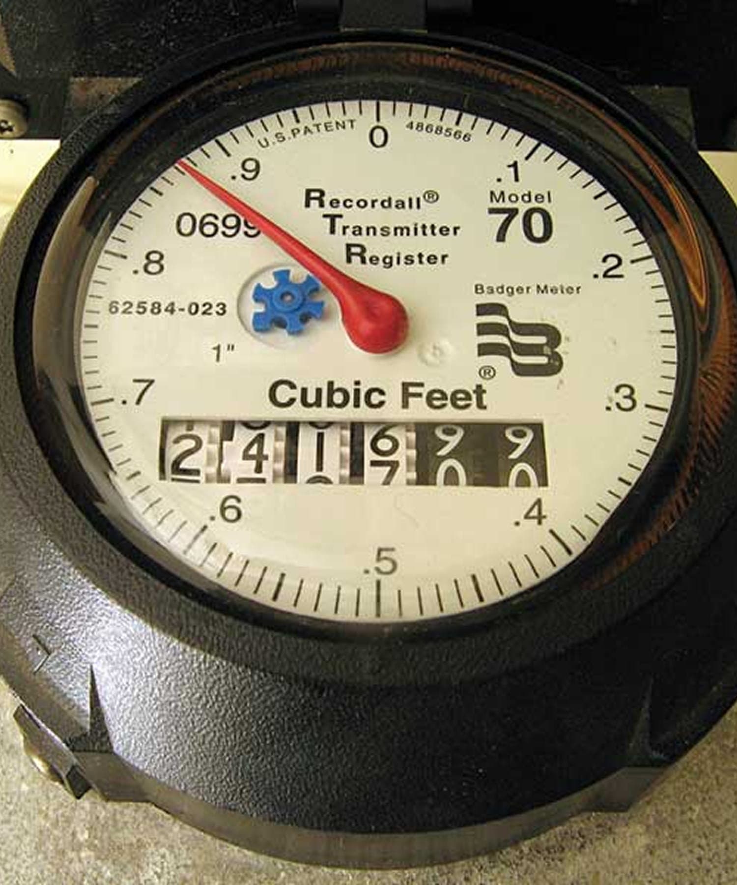 Close-up of an analog residential water meter reading.