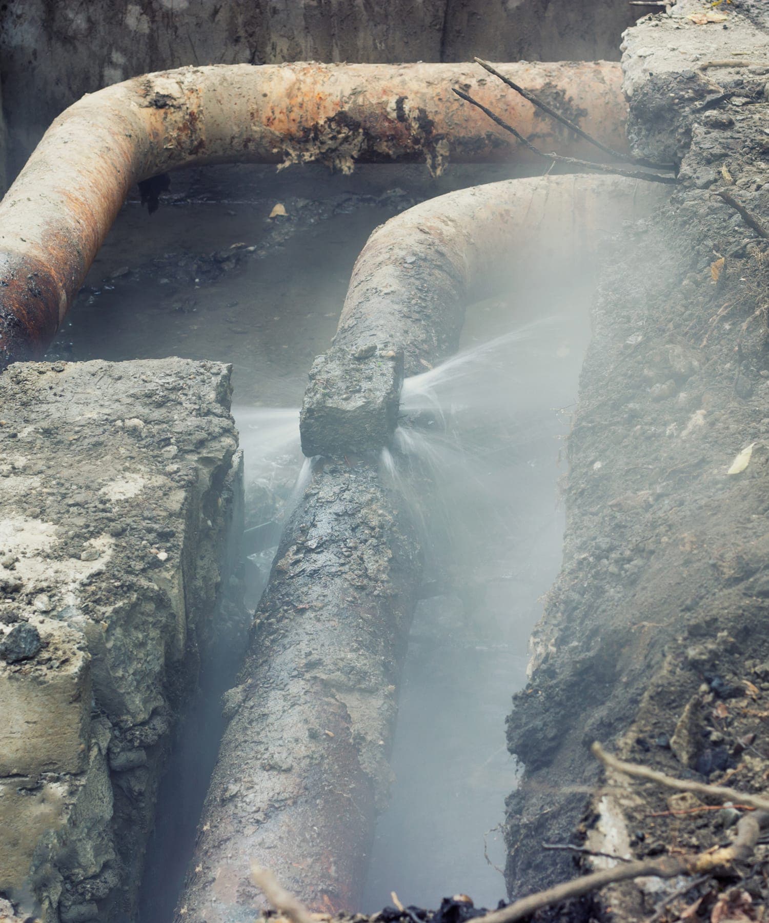 Exposed sewer pipe leaking inside an excavation.